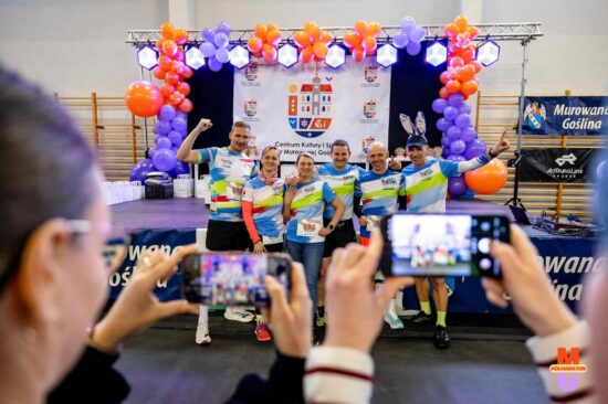 Zawodnicy fotografujac y się w biurze zawodów