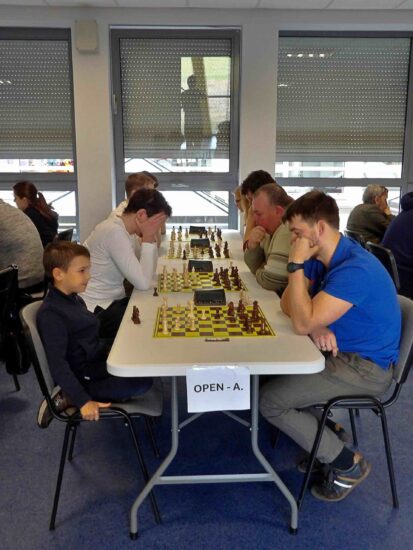 Szachiści przy stołach, szachownice, zegary