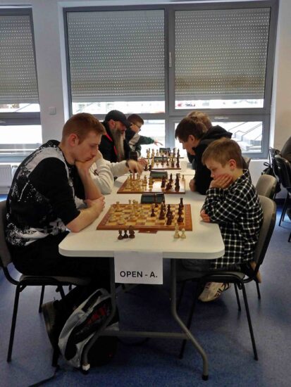 Szachiści przy stołach, szachownice, zegary