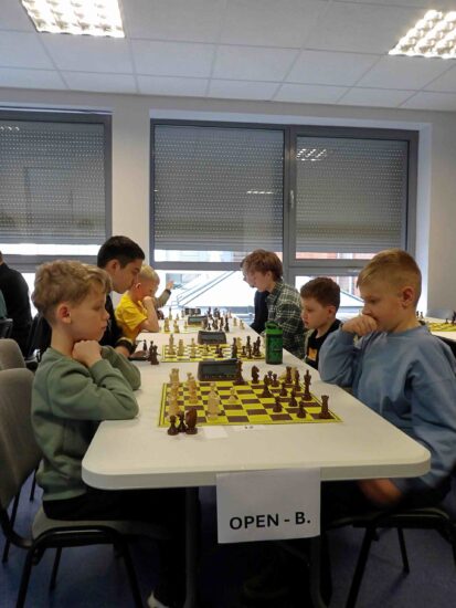 Szachiści przy stołach, szachownice, zegary