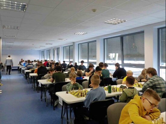 Szachiści przy stołach, szachownice, zegary