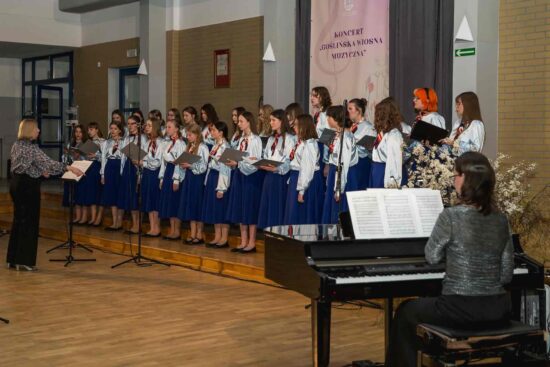 a pierwszym planie akompaniatorka Magdalena Holec grająca na fortepianie w tle Chór dziewczęcy Canzona -grupa starsza