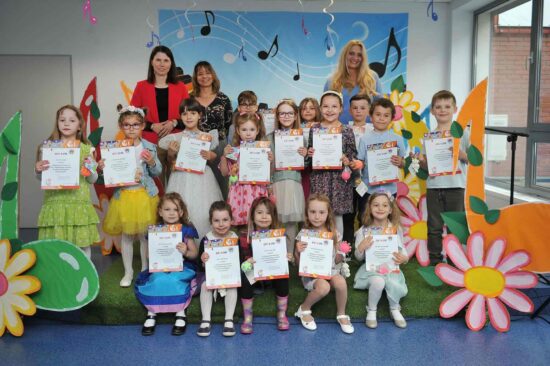Wszyscy uczestnicy festiwalu z jury pozują do zdjęcia. Dzieci trzymają w rękach pamiątkowe dyplomy