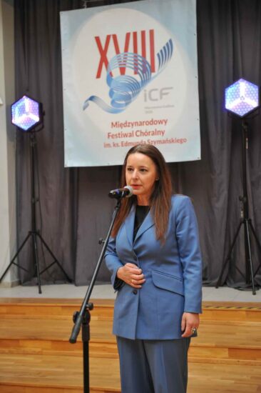 Kobieta z mikrofonem, baner festiwalowy w tle