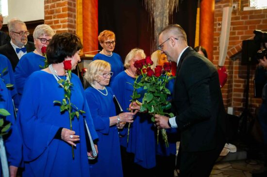 Dyrektor CKiS wręcza kwiaty chórzystą