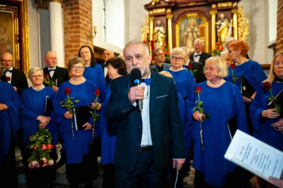 Prezes chóru z mikrofonem w ręku