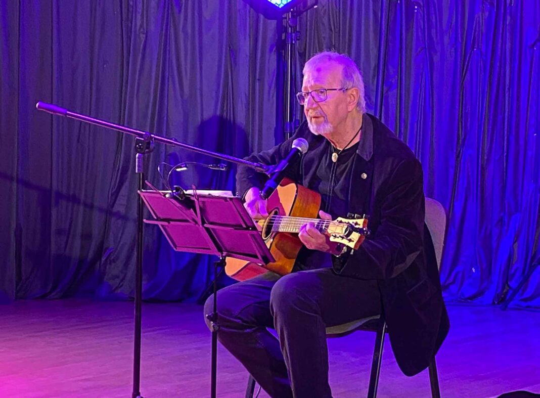 Artysta z gitarą występujący na scenie