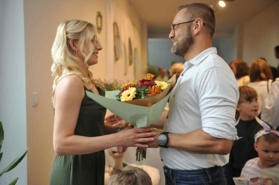 Mężczyzna wręcza bukiet kwiatów instruktorce