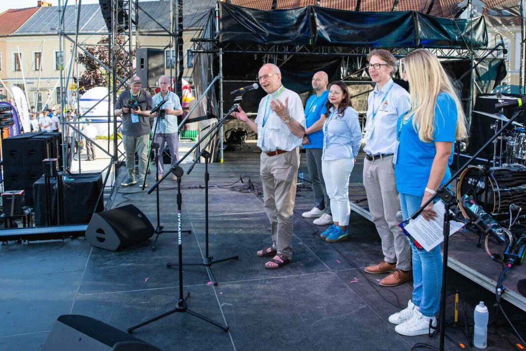 Na scenie przy mikrofonie stoi ks. proboszcz Sławomir Jessa z tyłu stoją CkiS Marcin Stroemich, burmistrz Justyna Radomska, zastępca burmistrza Marcin Buliński