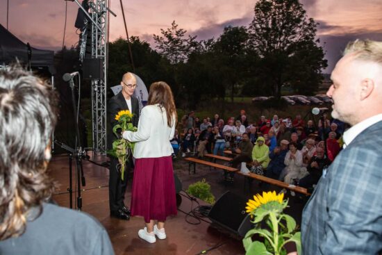 Burmistrz Justyna Radomska wręcza kwiaty dyrygentowi Michałowi Plichta